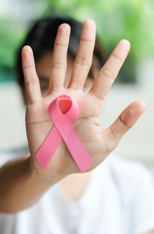 Close-Up Of Woman Hand Showing Breast Cancer Awareness Ribbon