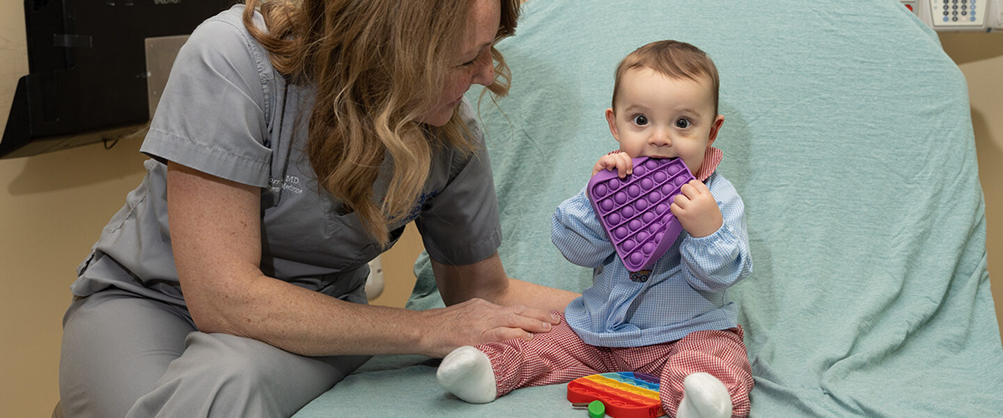 A baby and nurse playing with a sensory toy in a hospital bed