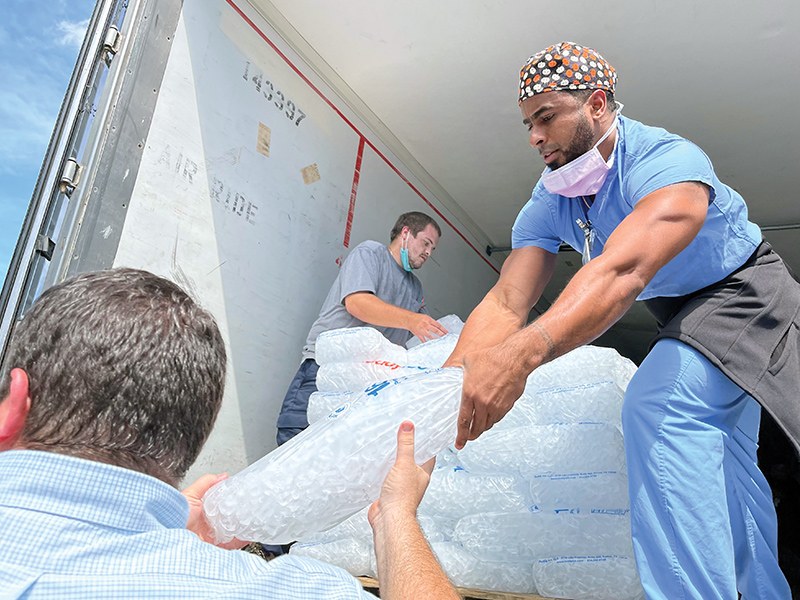 HCA Healthcare staff and volunteers work together to unload ice from a truck during Hurrican Ian support efforts.
