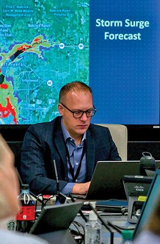 On site image inside the HCA Healthcare's Enterprise Emergency Operations Center where you can see the storm surge forecast and radar images while people work on their computers.